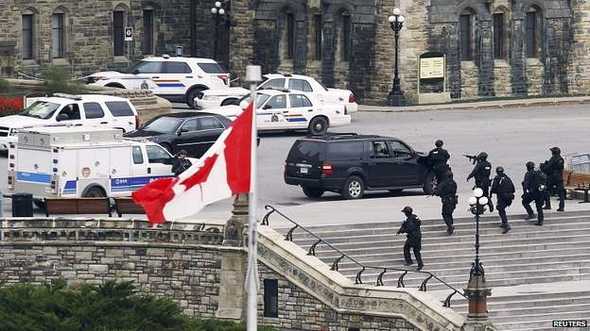 Grupos de policía armada se ven el los alrededores del edificio central del Parlamento en Ottawa. Grupos de policía armada se ven el los alrededores del edificio central del Parlamento en Ottawa.