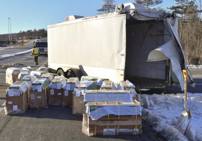 Las cajas con monos vivos se recogen junto al tráiler en el que se transportaban a lo largo de la Ruta estatal 54 en la intersección con la Interestatal 80 cerca de Danville, Pensilvania, el viernes 21 de enero de 2022, después de que una camioneta que tiraba del tráiler que transportaba a los monos fuera golpeada por un camión volquete. Transportaban 100 monos y varios andaban sueltos en el momento de la foto.