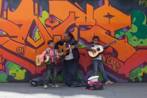 Una señora con dos menores de edad cantan en las calles de la Ciudad de México.