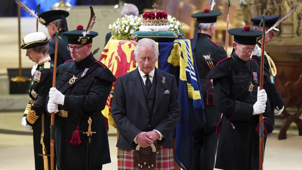 El rey Carlos III, la princesa Ana y el príncipe Andrés, con las cabezas inclinadas, rodean el ataúd de Isabel II junto a varios miembros de la Guardia real, 12 de septiembre de 2022