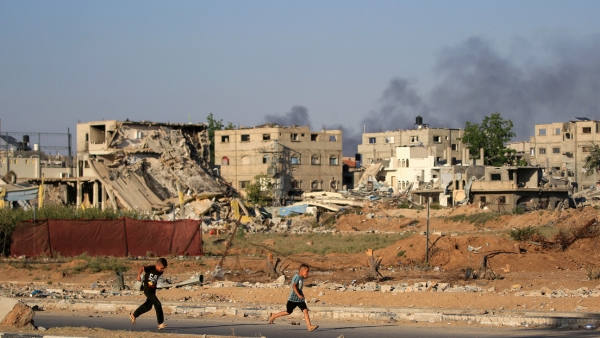 Niños palestinos corren mientras sale humo durante un bombardeo israelí al este del campo de refugiados de Al Bureij, en el centro de la Franja de Gaza, el 5 de junio de 2024.