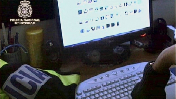 Un agente de la Policía Nacional revisa material intervenido en una operación contra la pedofilia.