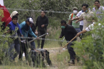 Integrantes de la Coordinadora Nacional de Trabajadores de la Educación (CNTE) se enfrentan a un elemento de la Policía Federal.