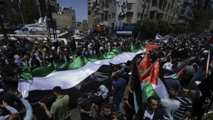 Palestinos marchan con su bandera en una manifestación para conmemorar el 75 aniversario de la Nakba, 15 de mayo de 2023.