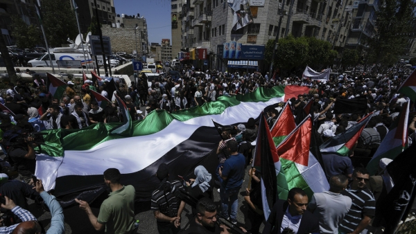 Palestinos marchan con su bandera en una manifestación para conmemorar el 75 aniversario de la Nakba, 15 de mayo de 2023.