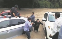 Personas auxiliaron a una joven que quedó atrapada dentro de su vehículo (color rojo) luego del desbordamiento del canal de avenida Patria.