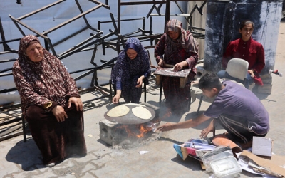 Los palestinos encienden un fuego para cocinar pan en una escuela de la ONU que alberga a personas desplazadas en la ciudad de Gaza el 4 de junio de 2024.