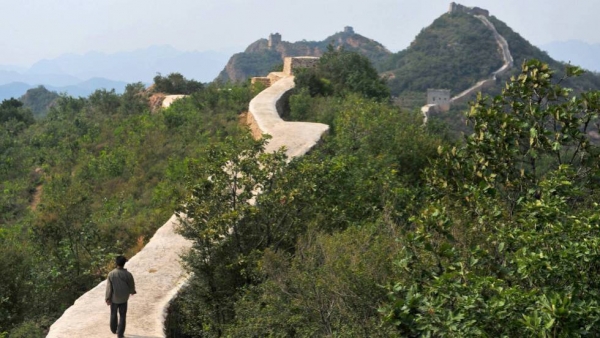 Una persona camina sobre el tramo de la muralla pavimentado.
