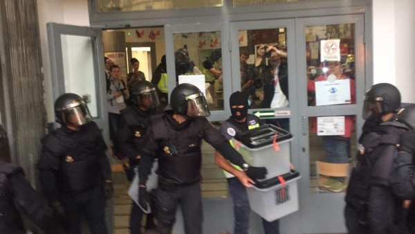 Policías nacionales españoles requisan urnas de un colegio electoral en Barcelona