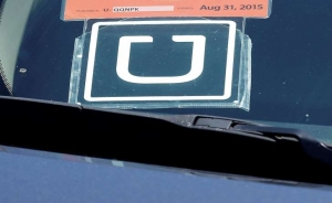 Se muestra un letrero de Uber en un auto estacionado cerca del Aeropuerto Internacional de San Francisco el miércoles 15 de julio de 2015