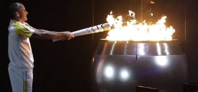 El atleta Vanderlei de Lima prende el pebetero olímpico durante la inauguración
