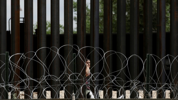 Una mujer migrante es vista tras cruzar ilegalmente a El Paso, EE.UU. 16 de julio de 2019.