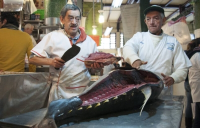 Dos comerciantes filetean un atún en el mercado de San Juan de la Ciudad de México.