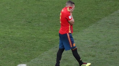 El jugador español Koke se cubre la cara con la camiseta tras fallar un penalti contra Rusia