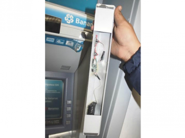 Personal bancario muestra el mecanismo que altera el funcionamiento de los cajeros en lugares concurridos.