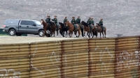 Miembros de la Patrulla de Fronteras de EEUU tras la valla de separación con México, a la altura de Tijuana, el 13 de marzo de 2018.