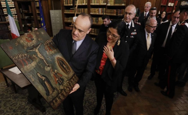 El ministro de Cultura italiano Alberto Bonisoli, a la izquierda, muestra a su homóloga mexicana, Alejandra Frausto, una de las 594 pinturas robadas de México Gregorio Borgia