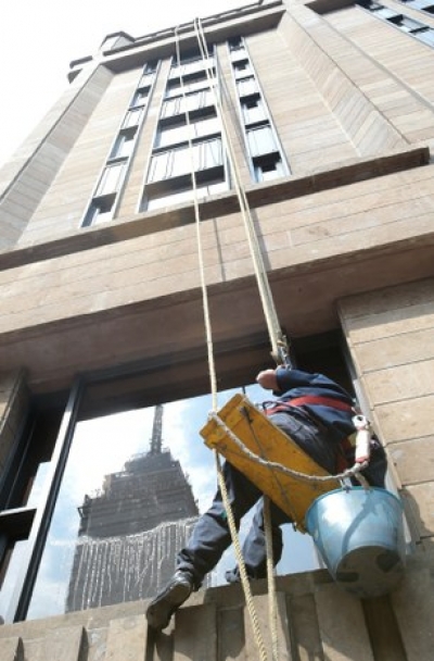Un trabajador limpia las ventanas de un edificio del Centro Histórico de la Ciudad de México.