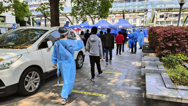 Los residentes hacen fila para la detección de covid-19 en un bloque residencial en Shanghái, China