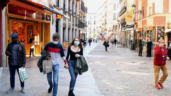 Gente con mascarilla en la inusualmente tranquila calle Postas, en el centro de Madrid. 13 de marzo de 2020.