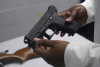 Una pistola de una colección de armas ilegales se revisa durante un evento de recompra de armas en Brooklyn, Nueva York, el 22 de mayo de 2021.