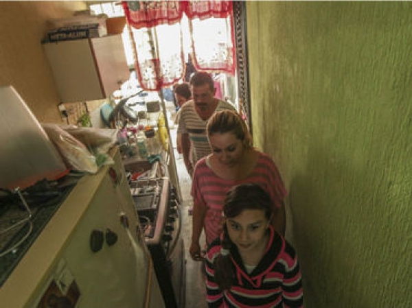 Debido a lo estrecho del espacio, la familia Gutiérrez cruza uno a uno por su cocina