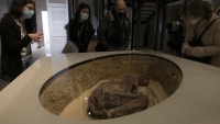Un guía turístico explica a los visitantes la historia del hallazgo arqueológico de una momia, Museo Egipcio de Turín (Italia), el 1 de febrero de 2021.