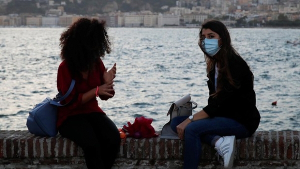 Jóvenes con mascarilla en Nápoles